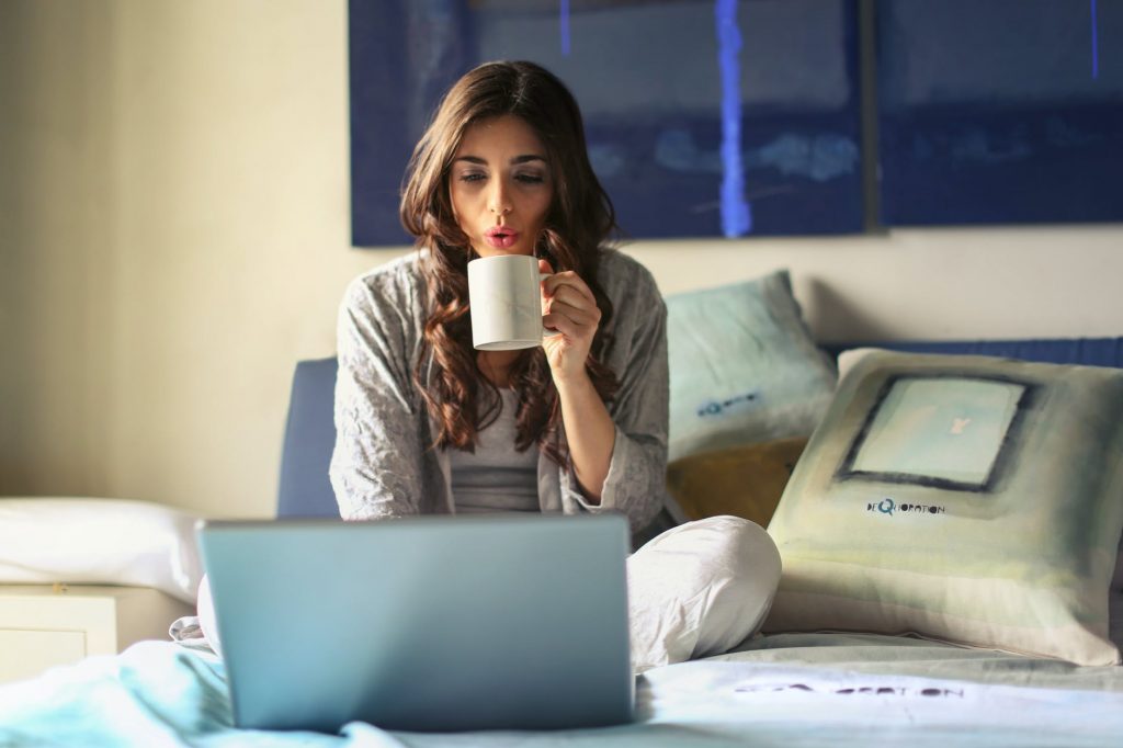 Woman in bed working on her laptop